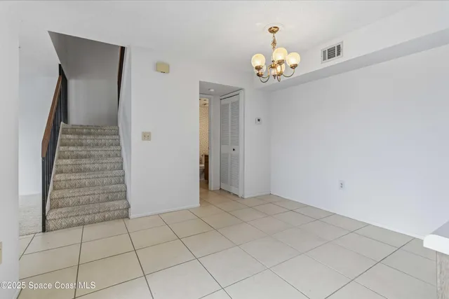 wooden floor in an empty room with a chandelier