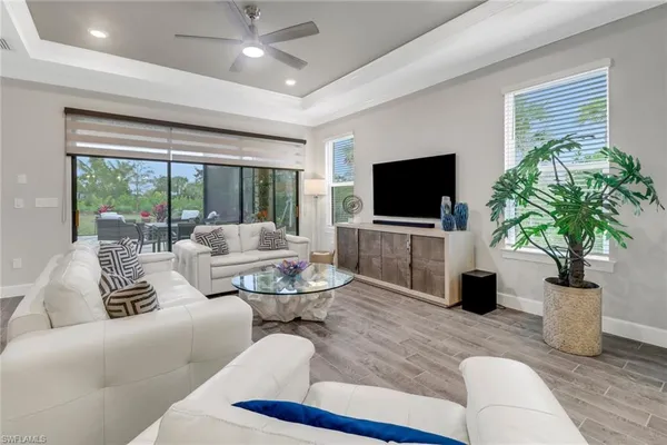 a living room with furniture potted plant and a large window