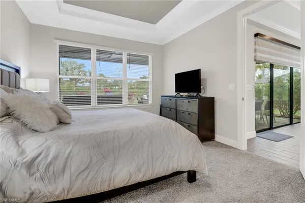 a bedroom with a bed and a flat tv screen next to a window