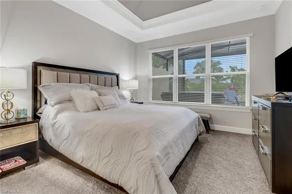 a bedroom with a bed and a flat tv screen on a dresser