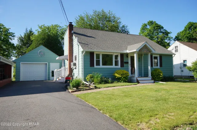 a front view of a house with a yard and potted plants
