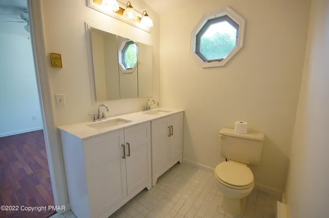 a bathroom with a toilet sink vanity and mirror