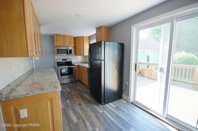 a kitchen with stainless steel appliances granite countertop a refrigerator and a sink