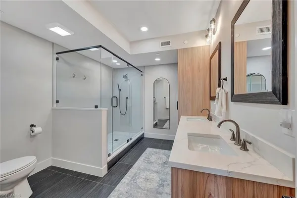 a bathroom with a double vanity sink mirror double and shower