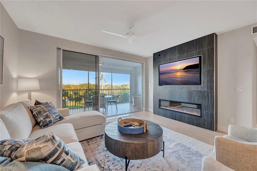 7671 Pebble Creek Circle, Unit 303 Naples, FL 34108 - Photo 2 of 28 Living Area with Fireplace Feature
