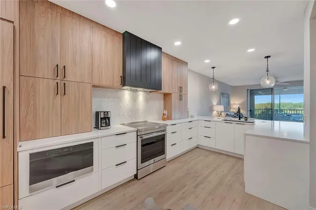a kitchen with stainless steel appliances white cabinets and wooden floors