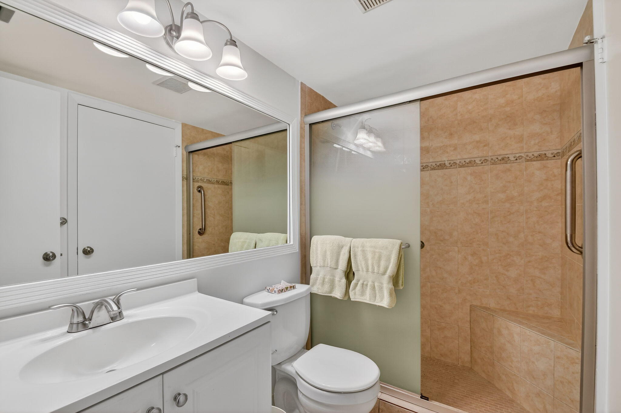 342 Pine Ridge Circle, Unit D1 Greenacres, FL 33463 - Photo 18 of 24 a bathroom with a sink a mirror a toilet and shower