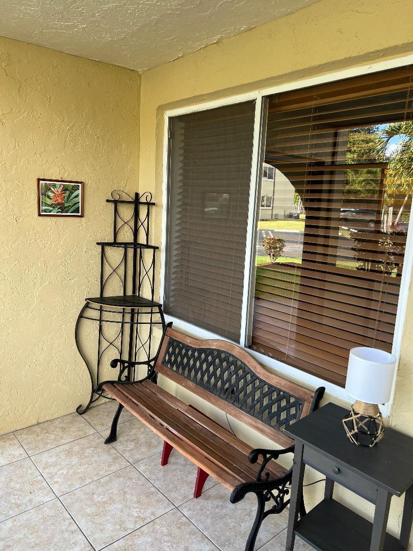 342 Pine Ridge Circle, Unit D1 Greenacres, FL 33463 - Photo 5 of 24 a view of a chairs and table in the balcony