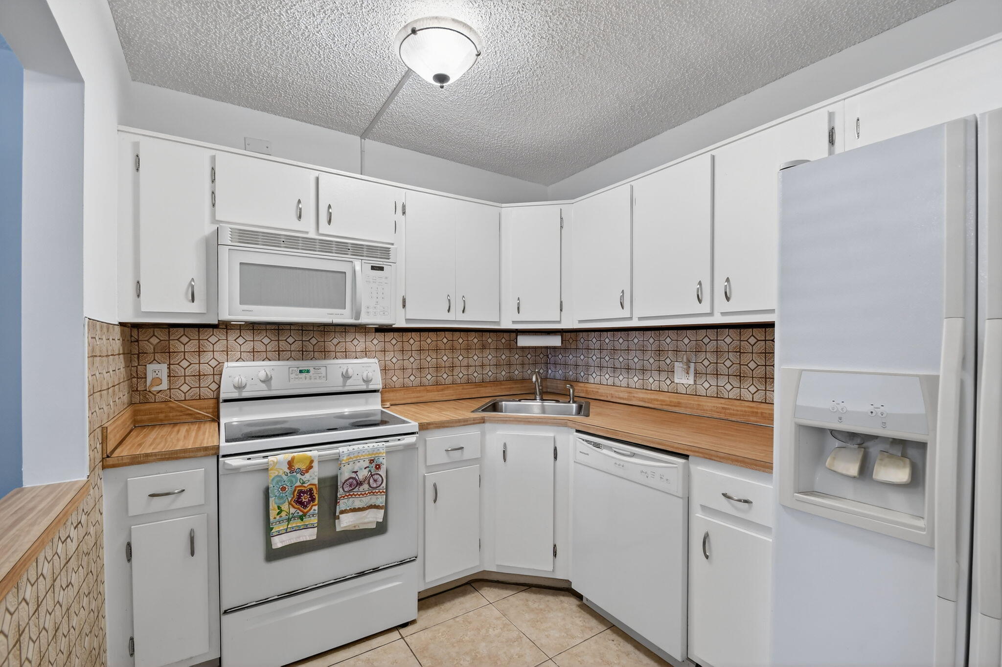 342 Pine Ridge Circle, Unit D1 Greenacres, FL 33463 - Photo 10 of 24 a kitchen with white cabinets and white appliances