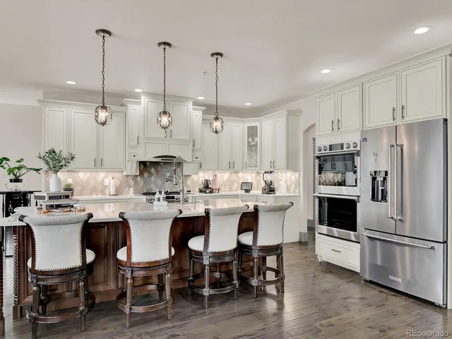 a kitchen with stainless steel appliances kitchen island granite countertop a lot of counter space and a sink
