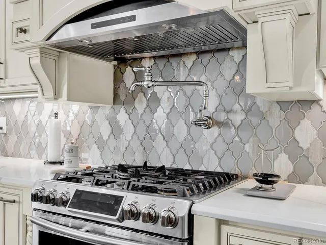 a view of a kitchen with kitchen island stainless steel appliances a sink center island and living room view