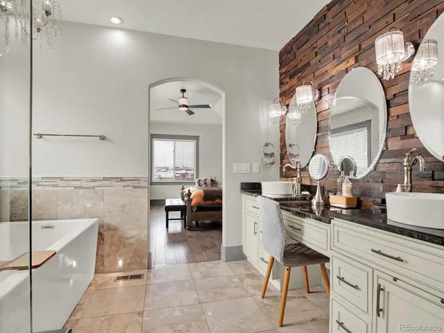 a bathroom with a tub a sink a mirror and shower
