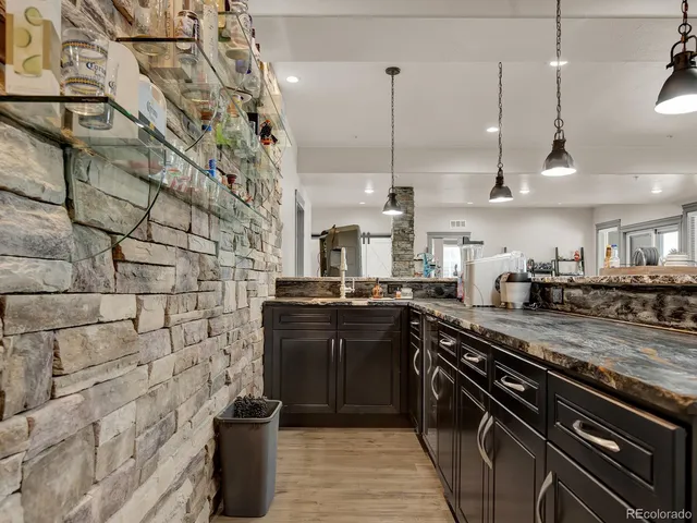 a kitchen with stainless steel appliances granite countertop a table and chairs in it