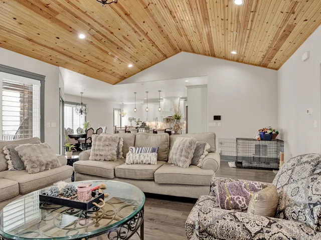 a kitchen with stainless steel appliances kitchen island granite countertop a dining table chairs and white cabinets