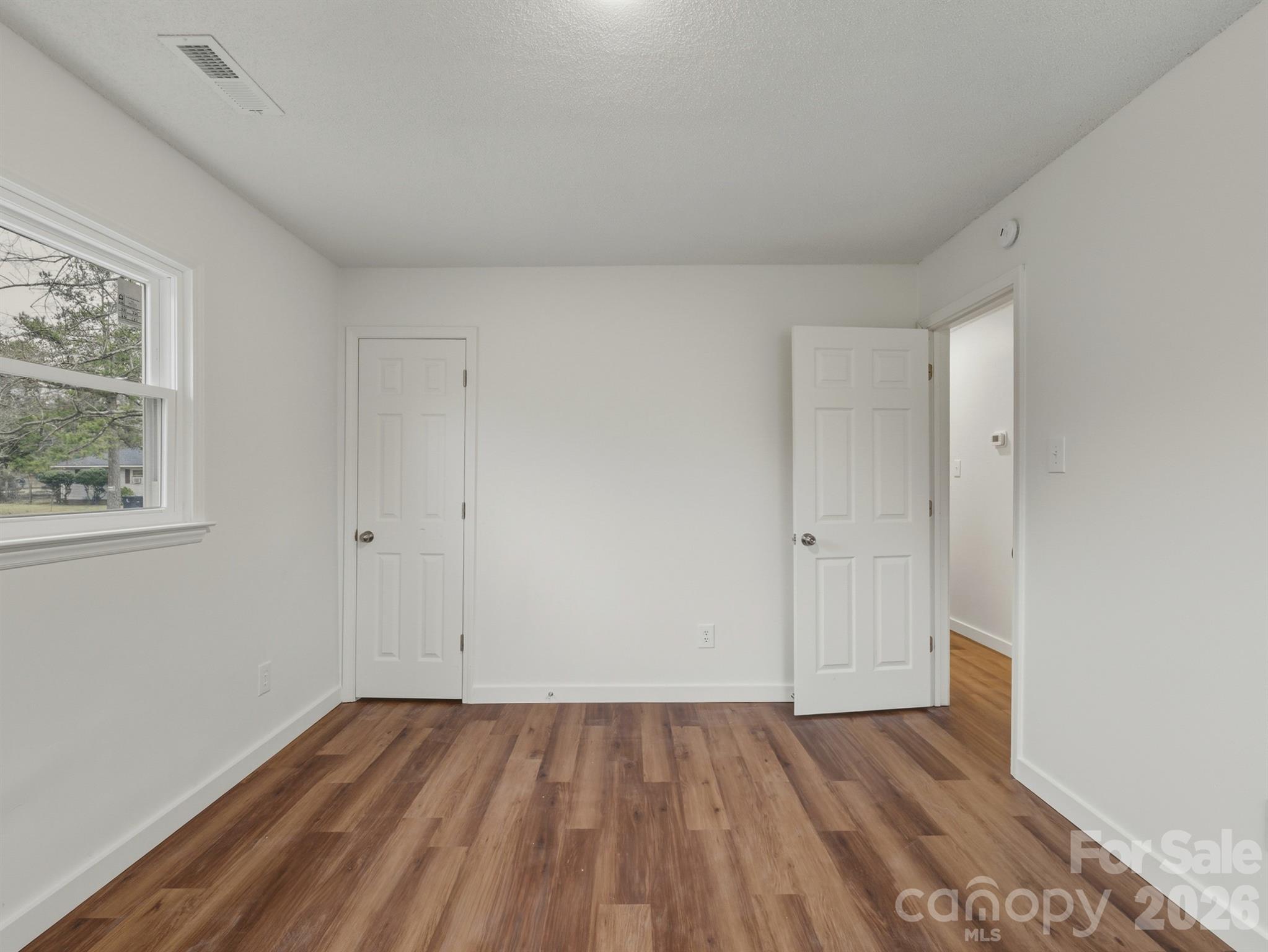 307 Jones Street Monroe, NC 28110 - Photo 20 of 22 a view of an empty room with wooden floor and a window
