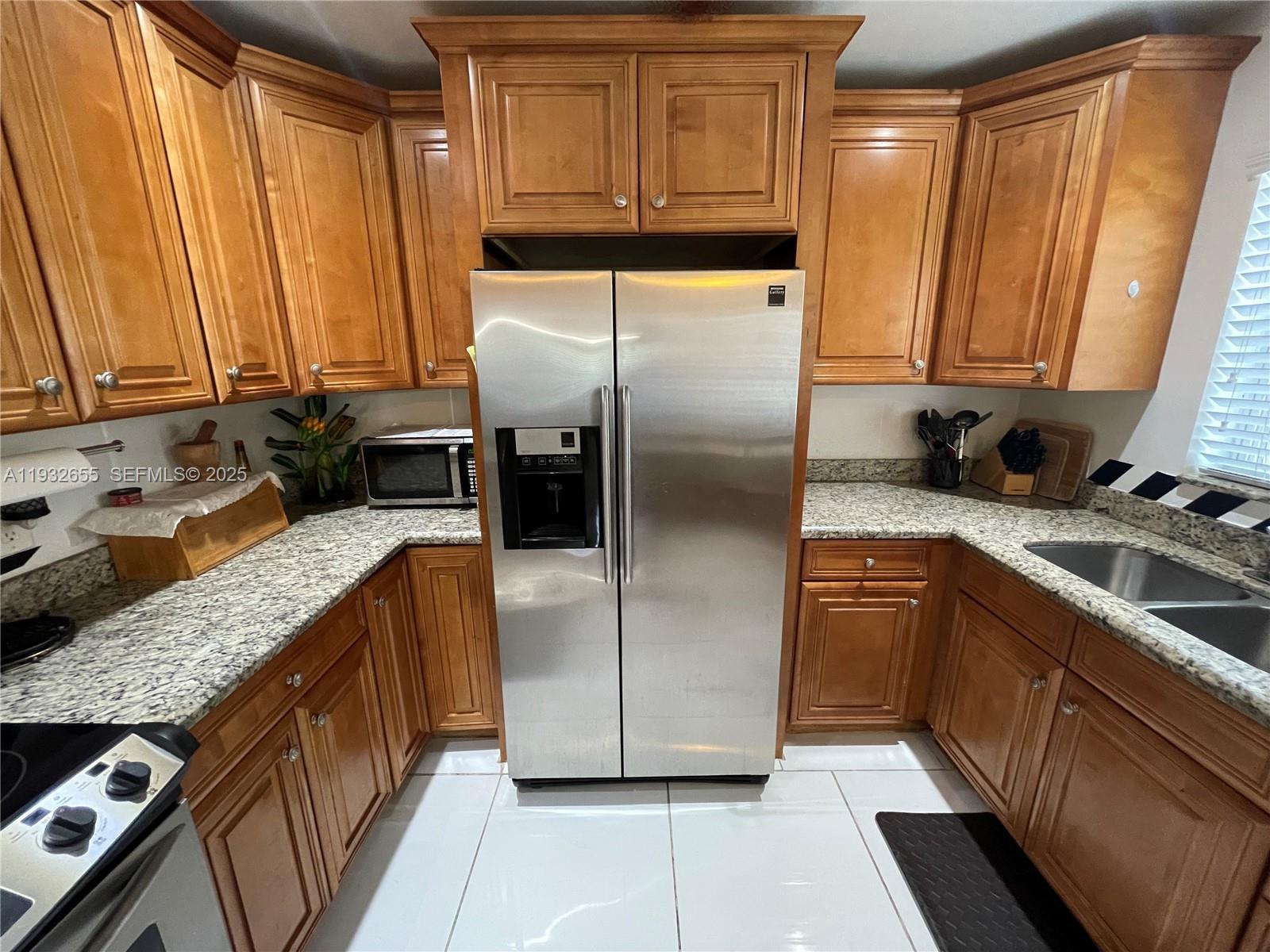 8951 Southwest 16th Street Boca Raton, FL 33433 - Photo 6 of 7 a kitchen with stainless steel appliances granite countertop a refrigerator a sink and a stove