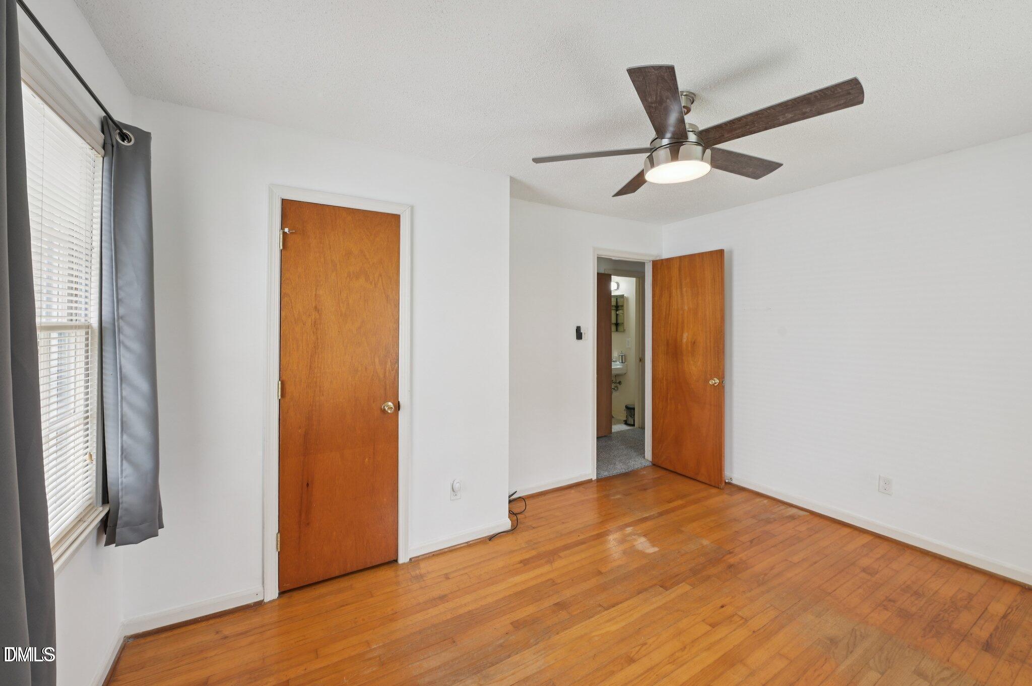 555 Dacian Road Raleigh, NC 27610 - Photo 13 of 16 a view of empty room with wooden floor and fan