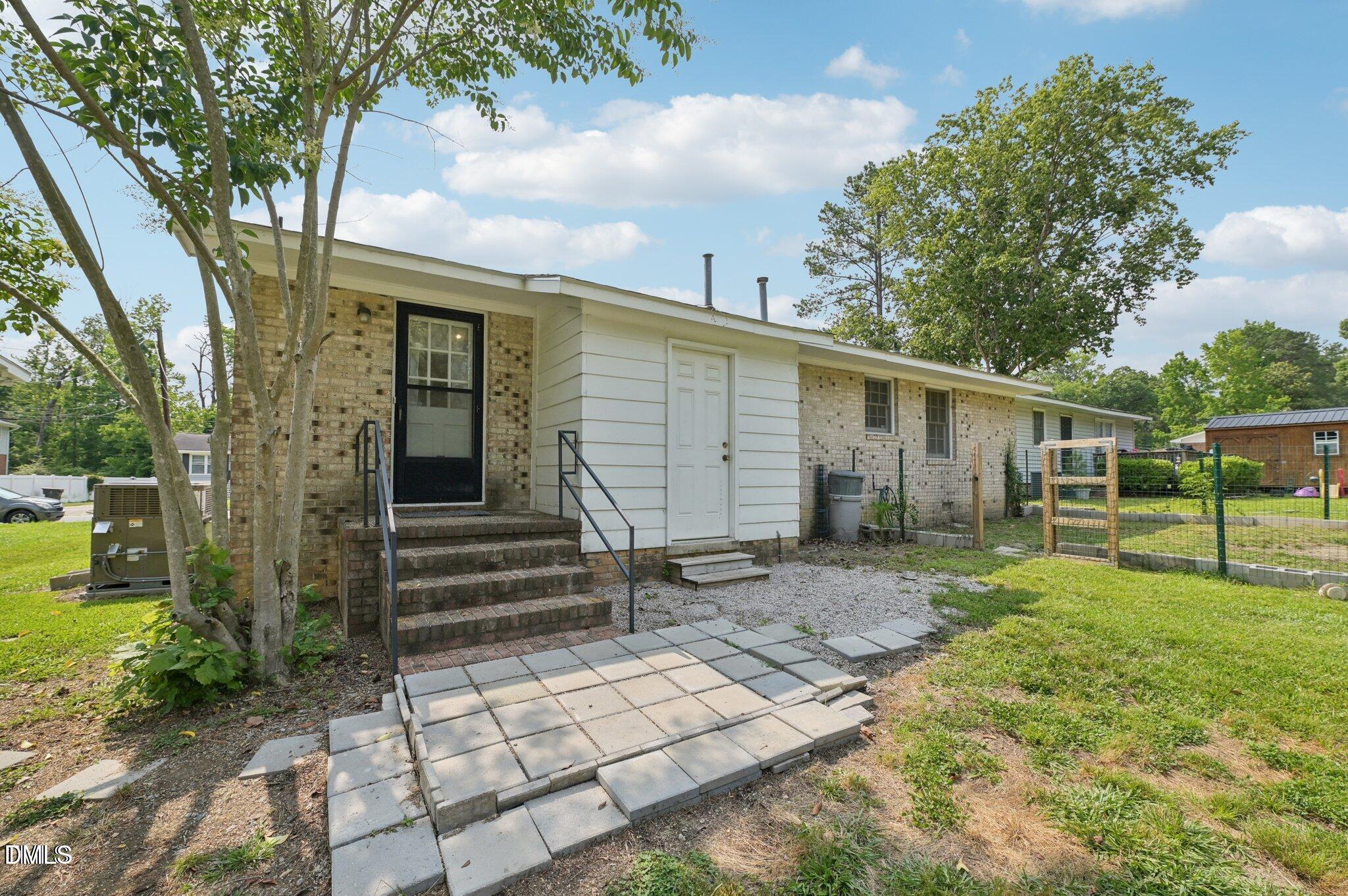 555 Dacian Road Raleigh, NC 27610 - Photo 2 of 16 a backyard of a house with plants and large tree