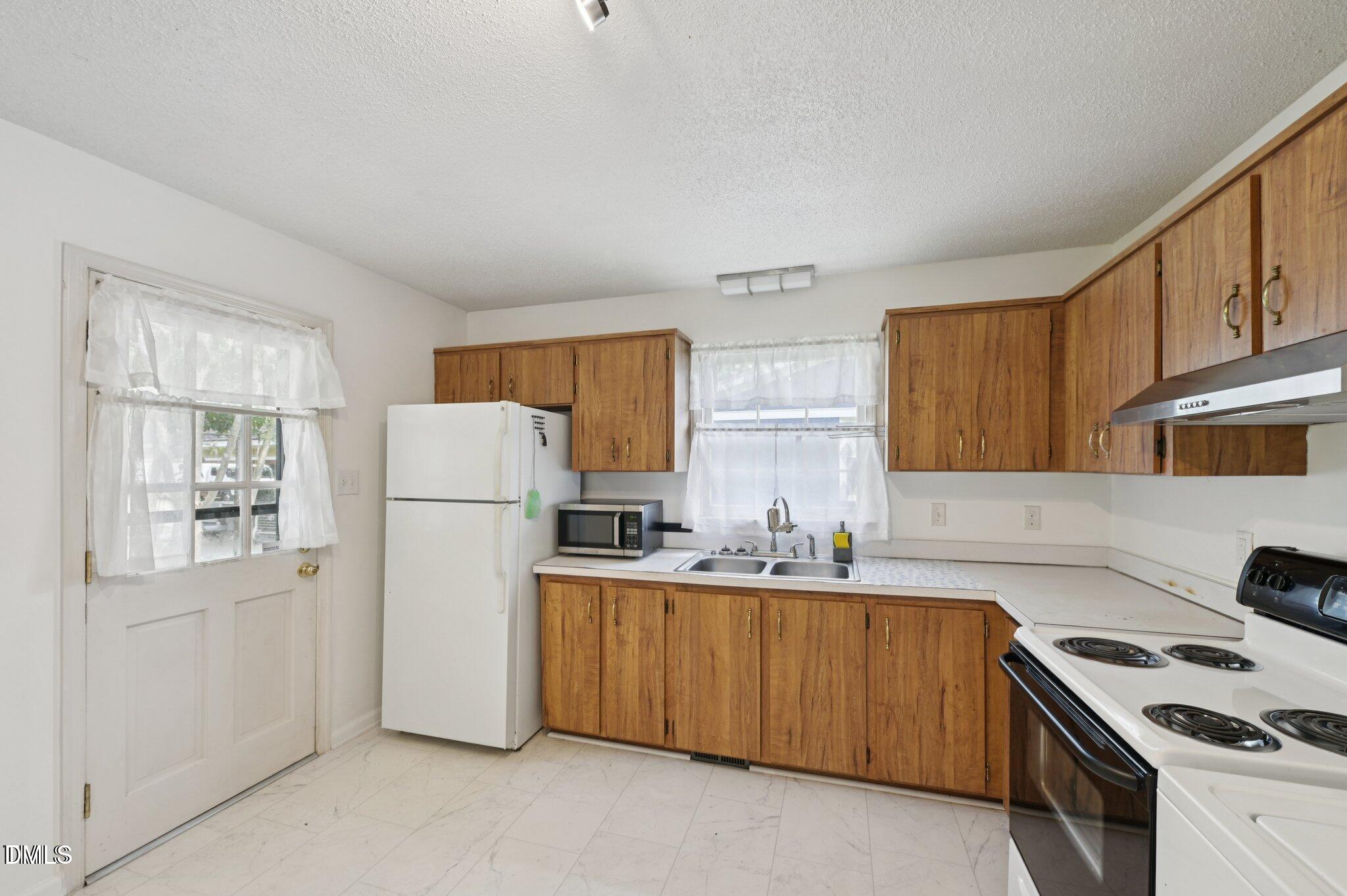 555 Dacian Road Raleigh, NC 27610 - Photo 9 of 16 a kitchen with a refrigerator sink stove and cabinets
