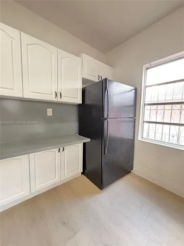 a kitchen with refrigerator and window