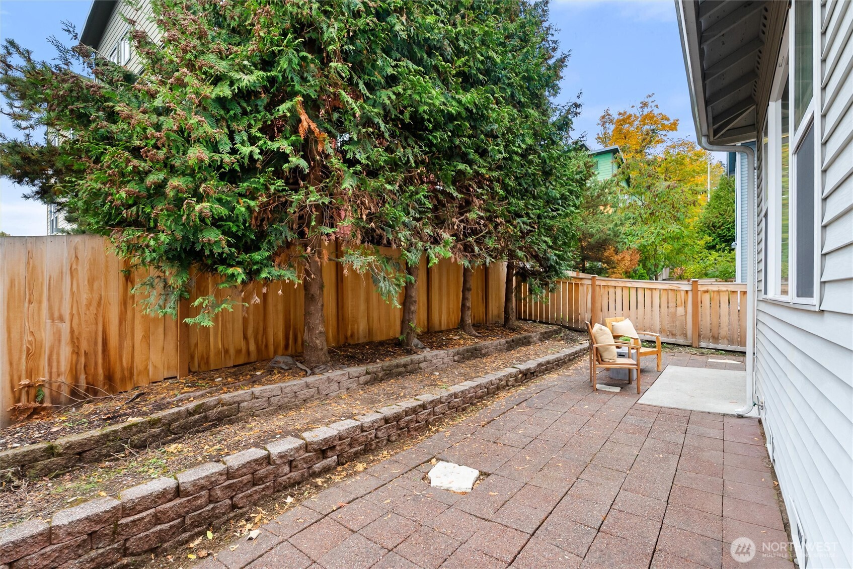 3957 South Chicago Street Seattle, WA 98118 - Photo 32 of 34 a view of a backyard with large trees and wooden fence