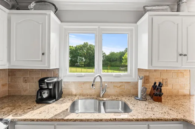a kitchen with granite countertop a sink and a stove top oven