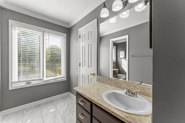 a bathroom with a sink a mirror and a window