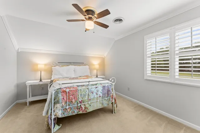 a bedroom with a bed chandelier and a window