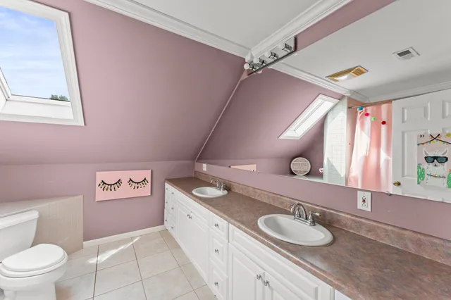 a spacious bathroom with a granite countertop sink mirror vanity and toilet
