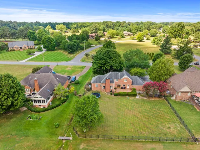 an aerial view of a house with a garden and lake view