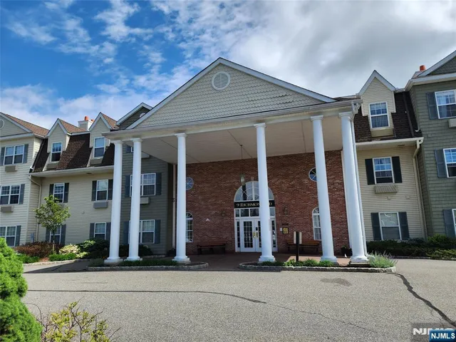 front view of a brick house with a yard
