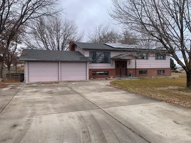 a front view of a building with a garden and trees