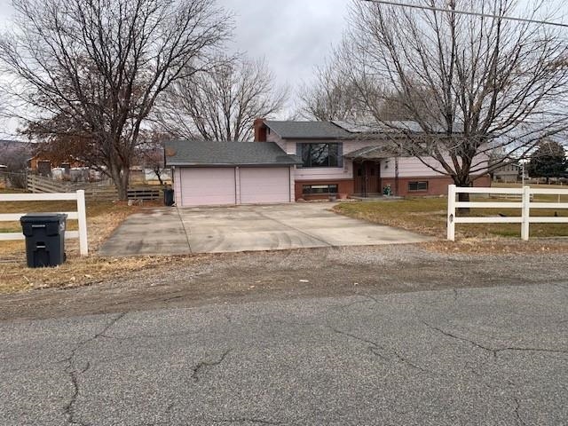 581-22 22 1/2 Road Grand Junction, CO 81507 - Photo 2 of 26 a front view of a house with a yard and garage