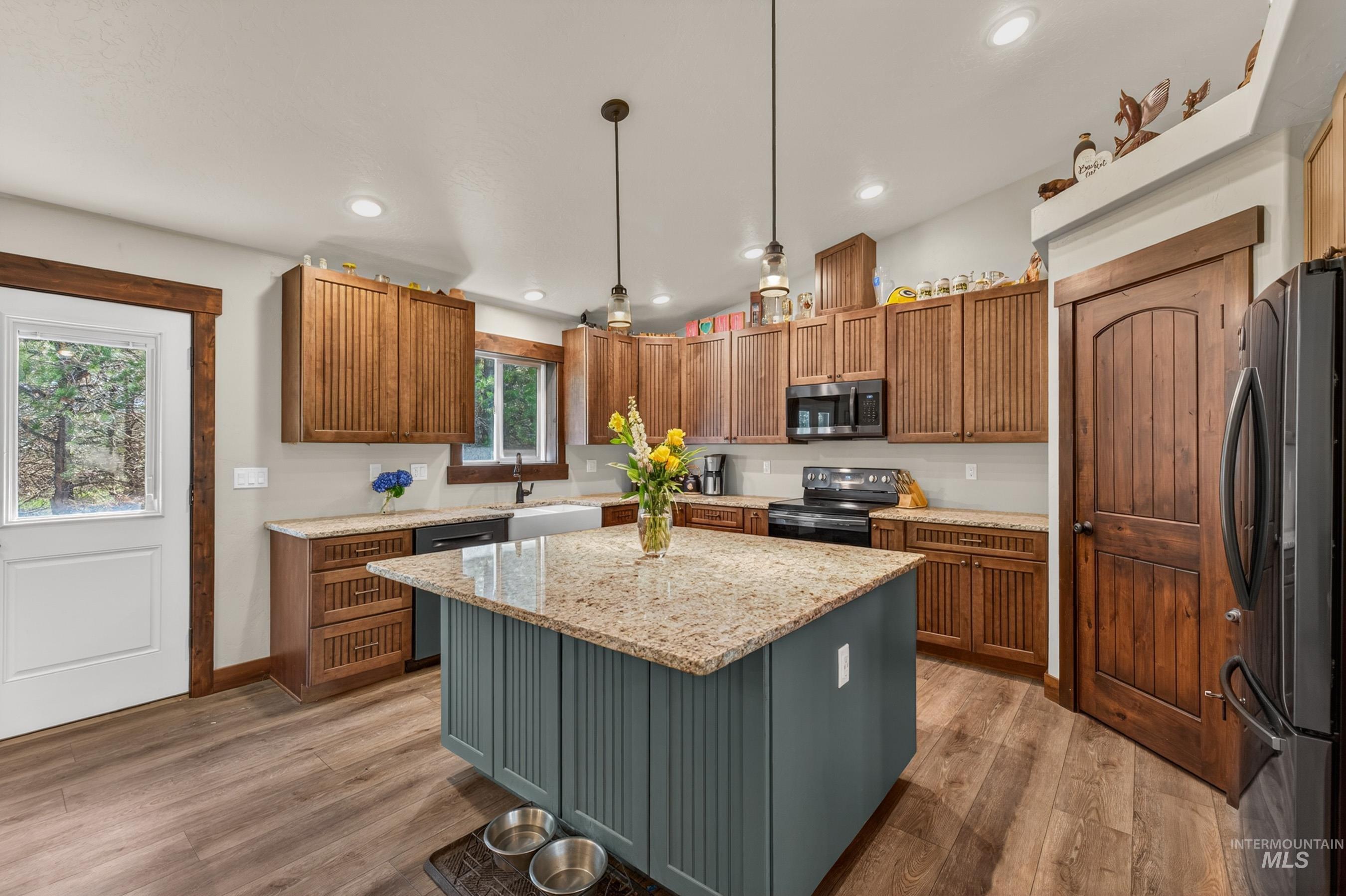 13388 Norwood Road McCall, ID 83638 - Photo 11 of 44 Spacious kitchen featuring a central island with a granite countertop, wood-finish flooring, recessed lighting, and ample wood cabinetry
