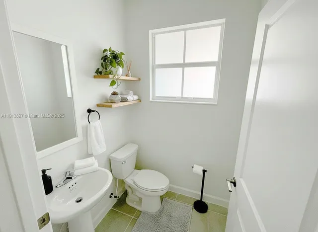 a white toilet sitting next to a bathroom sink