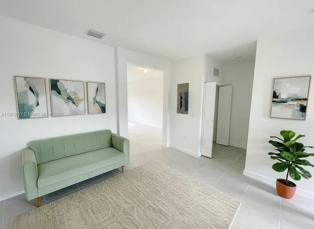 a living room with furniture and a potted plant
