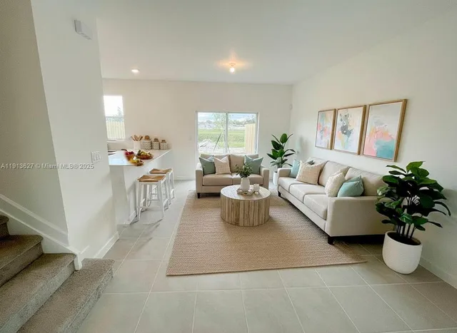 a living room with furniture and a potted plant