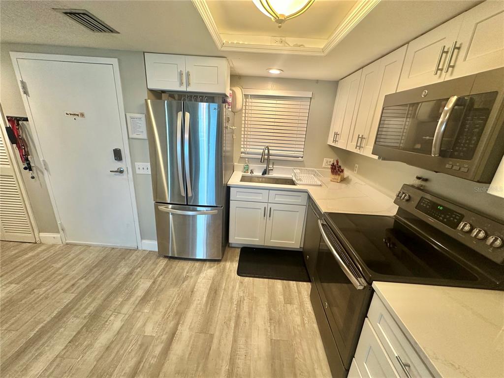 6009 Sea Ranch Drive, Unit 314 Hudson, FL 34667 - Photo 5 of 66 a kitchen with stainless steel appliances a refrigerator a sink a stove and cabinets