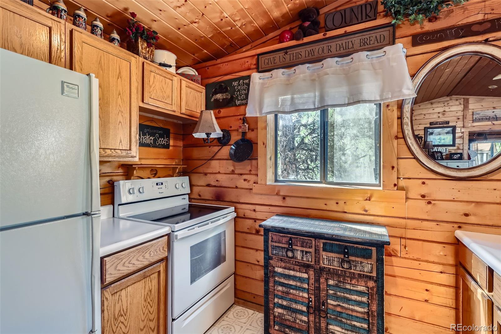 398 Gross Road Bailey, CO 80421 - Photo 11 of 28 a kitchen that has a stove and a white cabinets