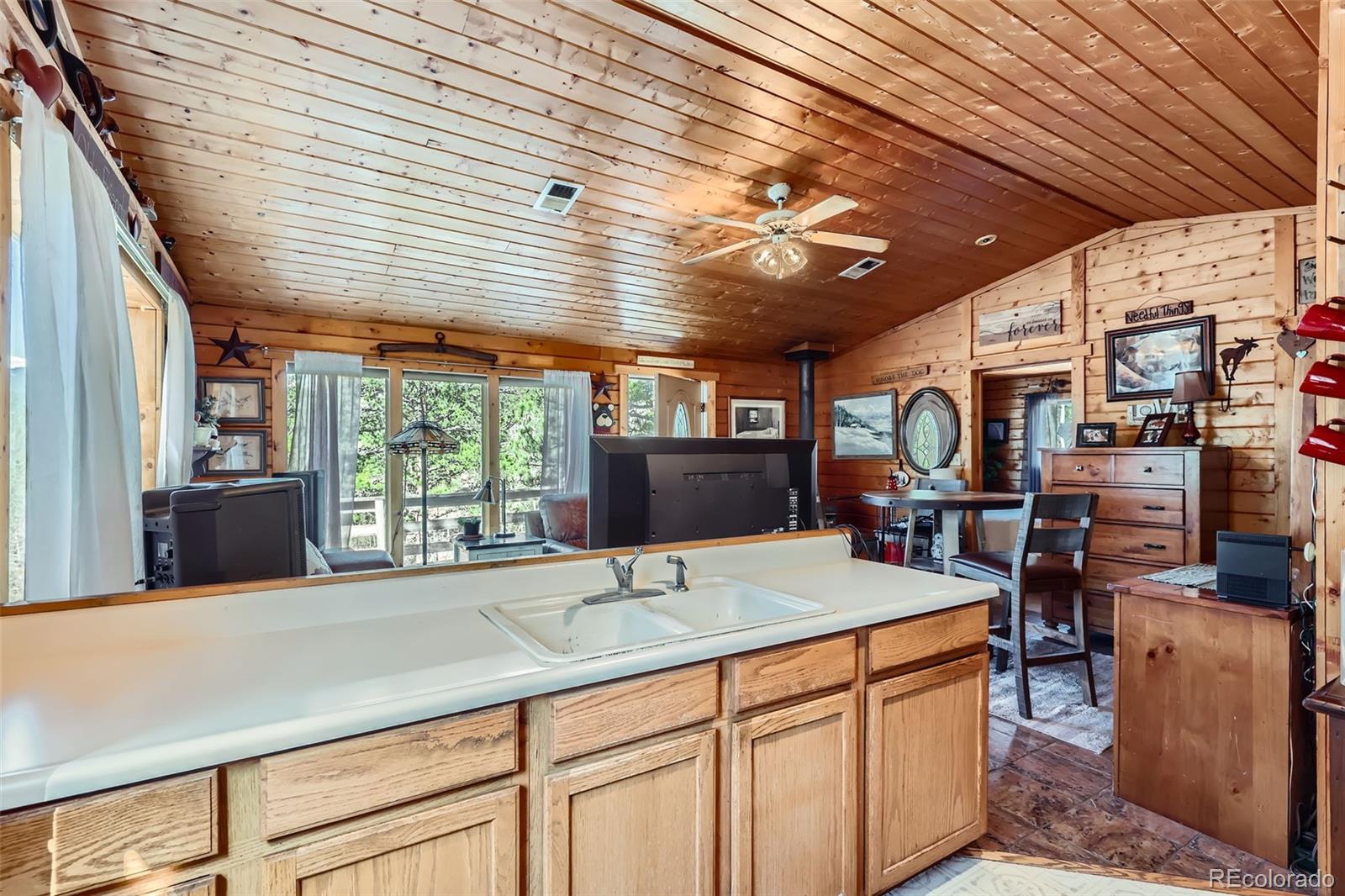 398 Gross Road Bailey, CO 80421 - Photo 12 of 28 a kitchen with kitchen island granite countertop a sink stainless steel appliances wooden floor and large window