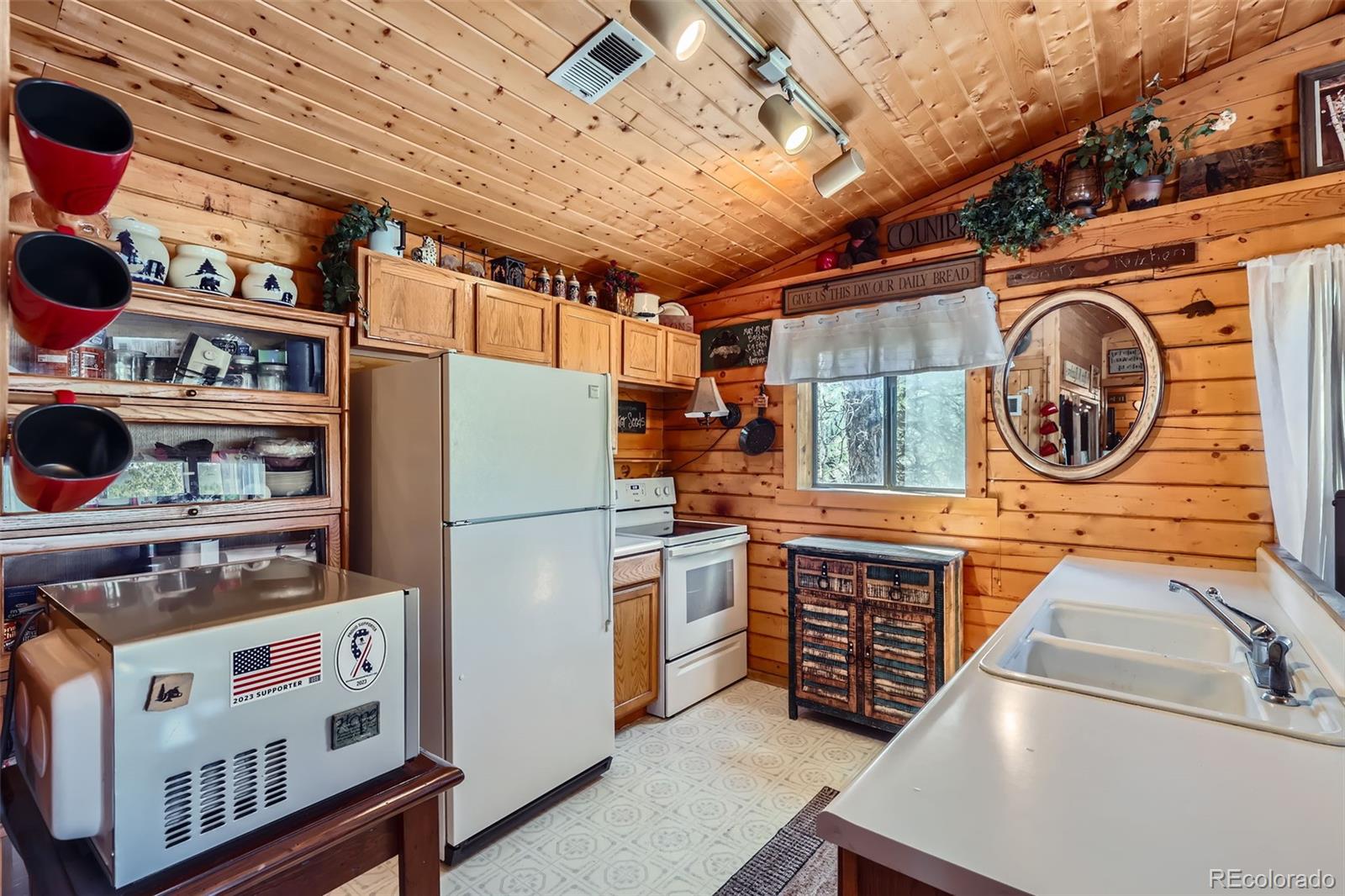 398 Gross Road Bailey, CO 80421 - Photo 9 of 28 a kitchen with stainless steel appliances granite countertop a stove and a refrigerator
