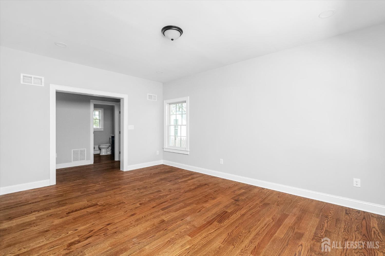 440 Ellisdale Road Chesterfield, NJ 08515 - Photo 6 of 42 a view of an empty room with wooden floor and a window