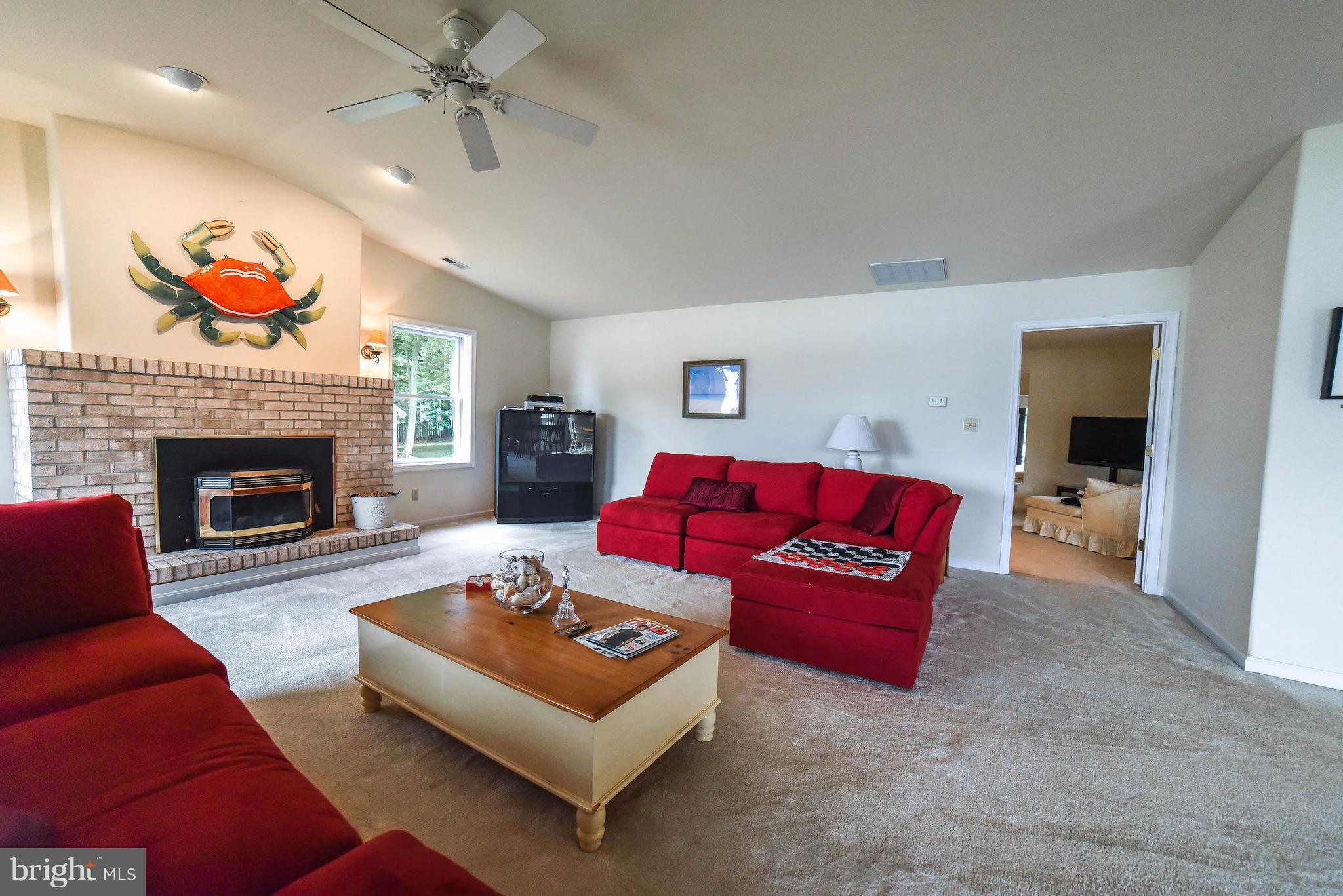 16215 Osprey Cove Ln Ridge Ridge, MD 20680 - Photo 17 of 30 a living room with furniture and a fireplace