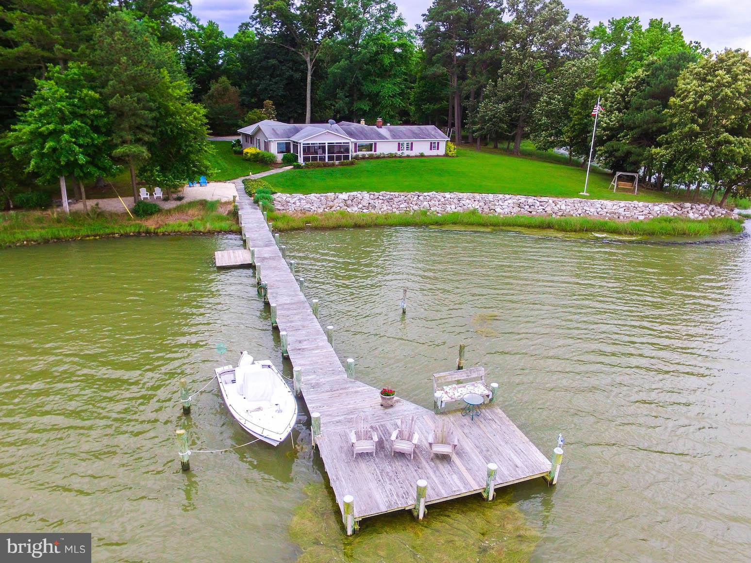 16215 Osprey Cove Ln Ridge Ridge, MD 20680 - Photo 8 of 30 a view of a lake with a bench and trees around
