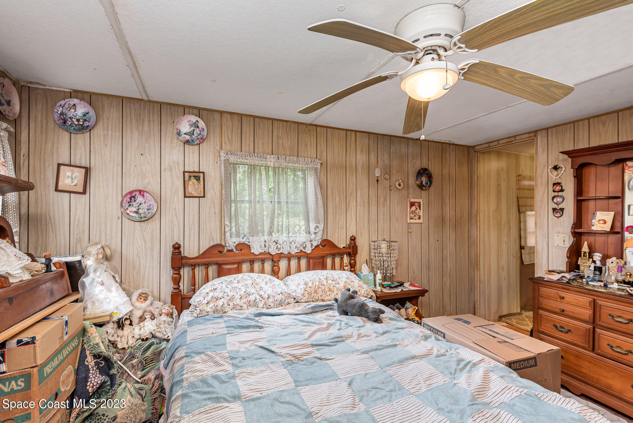 4173 Aurantia Road Mims, FL 32754 - Photo 12 of 23 a bedroom with a bed and a chandelier