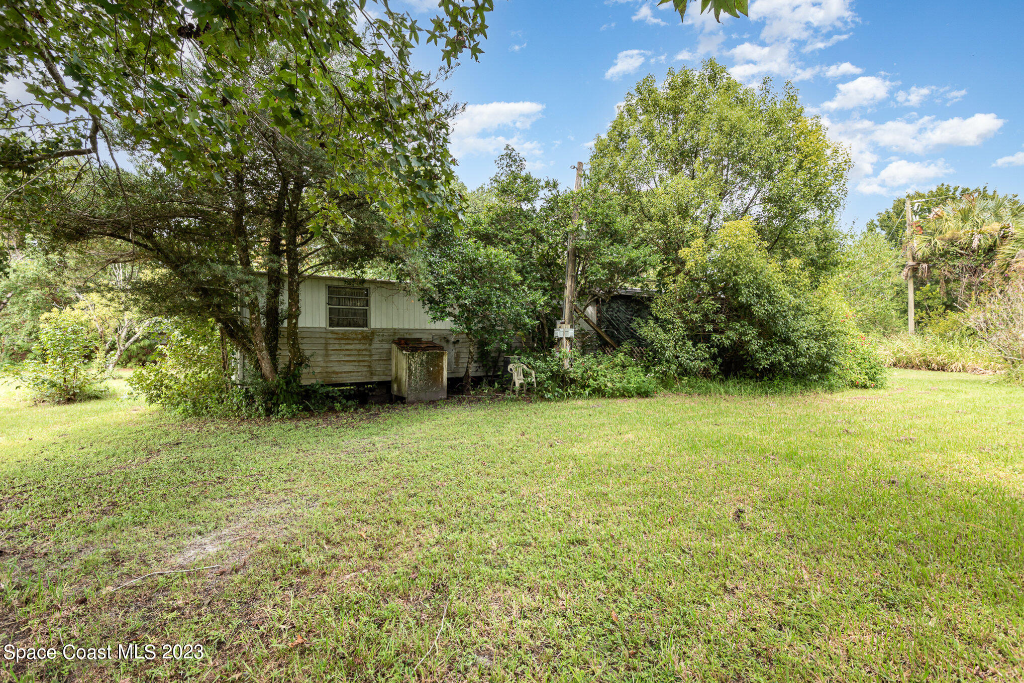 4173 Aurantia Road Mims, FL 32754 - Photo 20 of 23 a house is sitting in middle of the green field