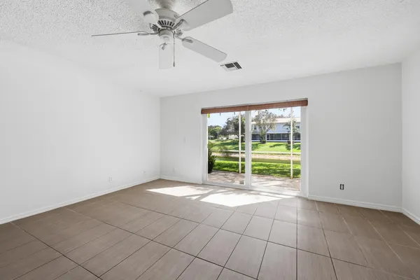 a view of an empty room with a fireplace and a window