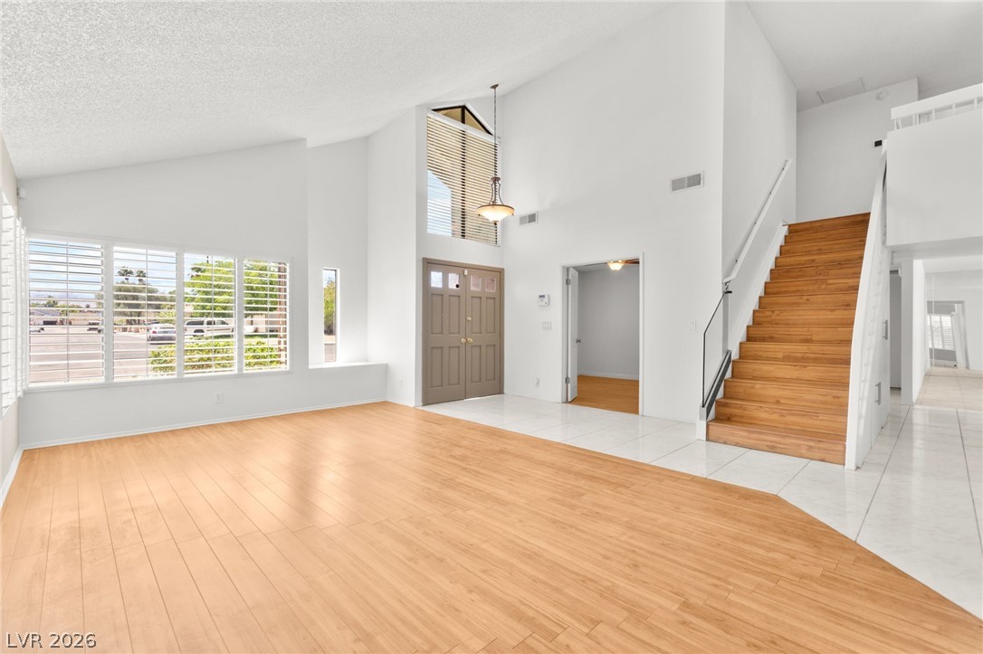 4430 Cranbrook Way Las Vegas, NV 89103 - Photo 50 of 50 Natural light illuminates the open floorplan with high ceilings, featuring a blend of wood and tile flooring.