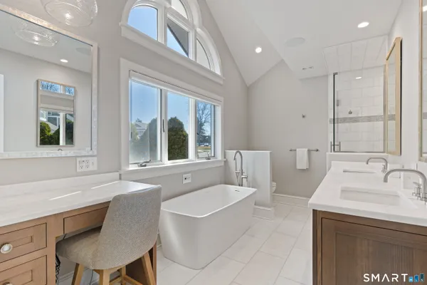 a bathroom with a granite countertop sink a toilet a mirror and bathtub