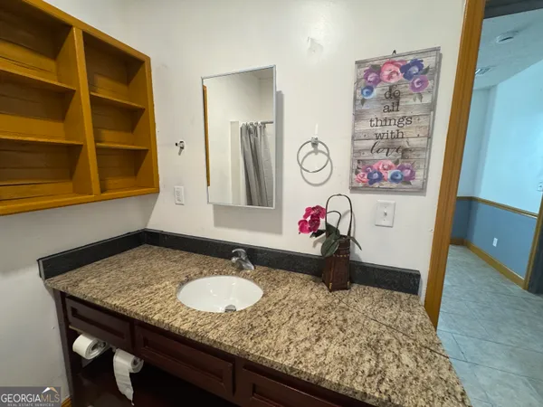 a bathroom with a granite countertop sink and a mirror